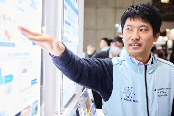 Sumitomo Metal Mining staff explaining the exhibit to visitors