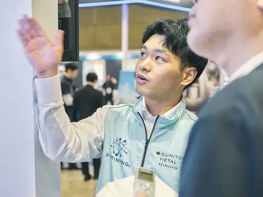 A Sumitomo Metal Mining representative from the Materials Laboratories explaining the exhibit to visitors