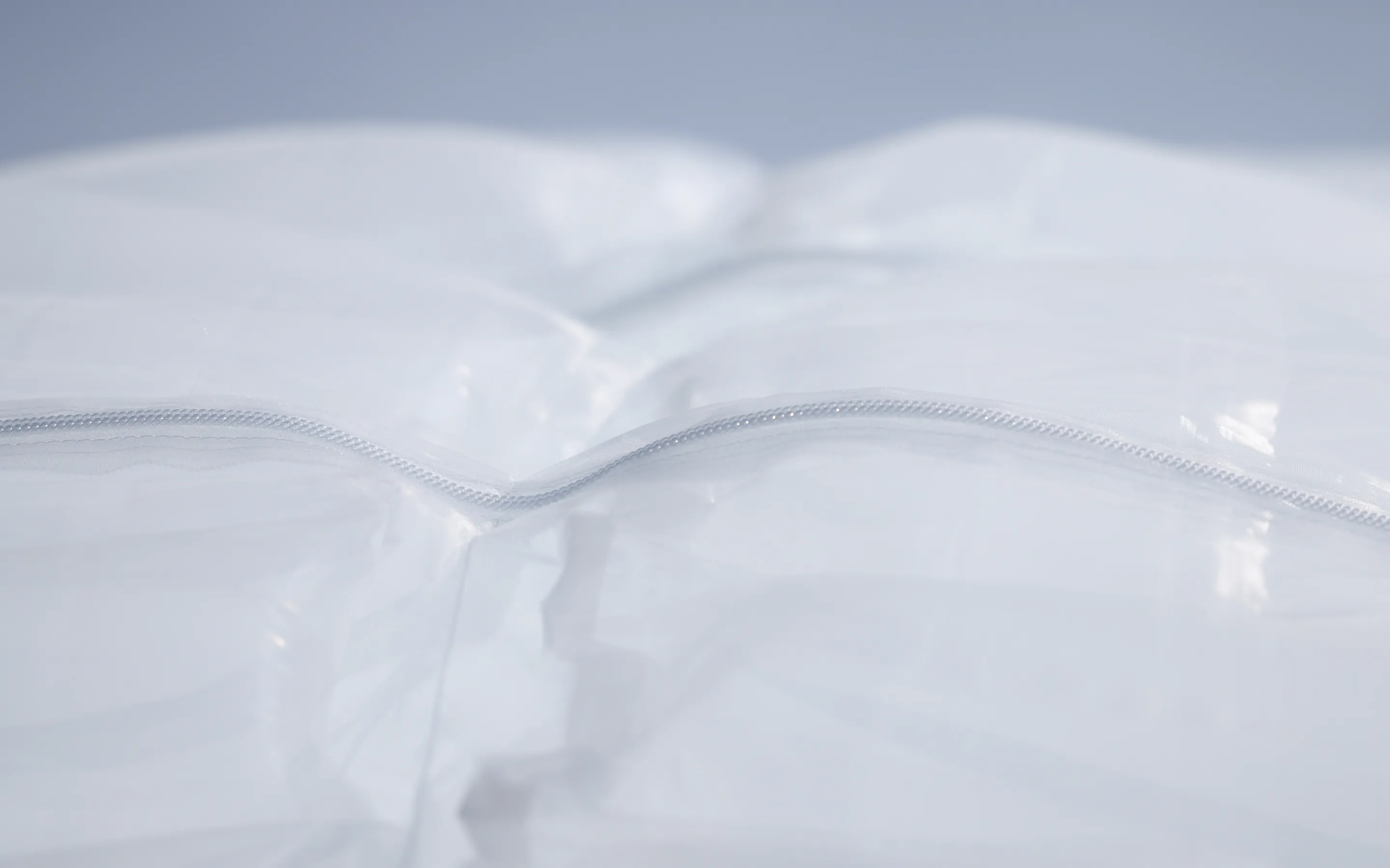 Close-up of SOLAMENT™ material that unlocks new forms of fashion. Its translucent surface and seamless zipper symbolize heat-blocking functionality and a sleek design.