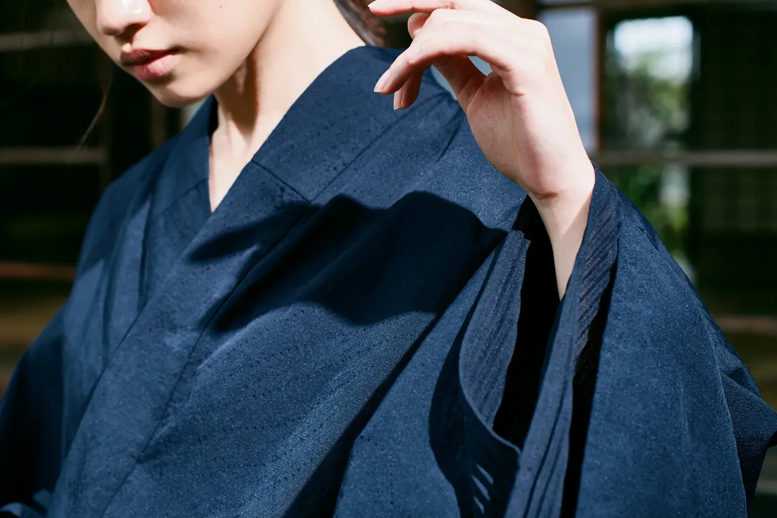 Upper-body view of HOPE WEAR for Culture with fine punching on deep navy fabric and layered pleated sleeves for breathability.