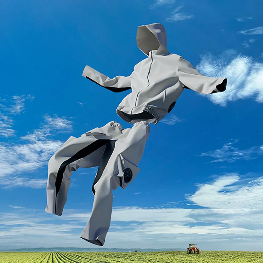Visual of a white agricultural workwear set (top and bottom) with built-in fans, HOPE WEAR for Farm Type A, floating against a vivid blue sky.