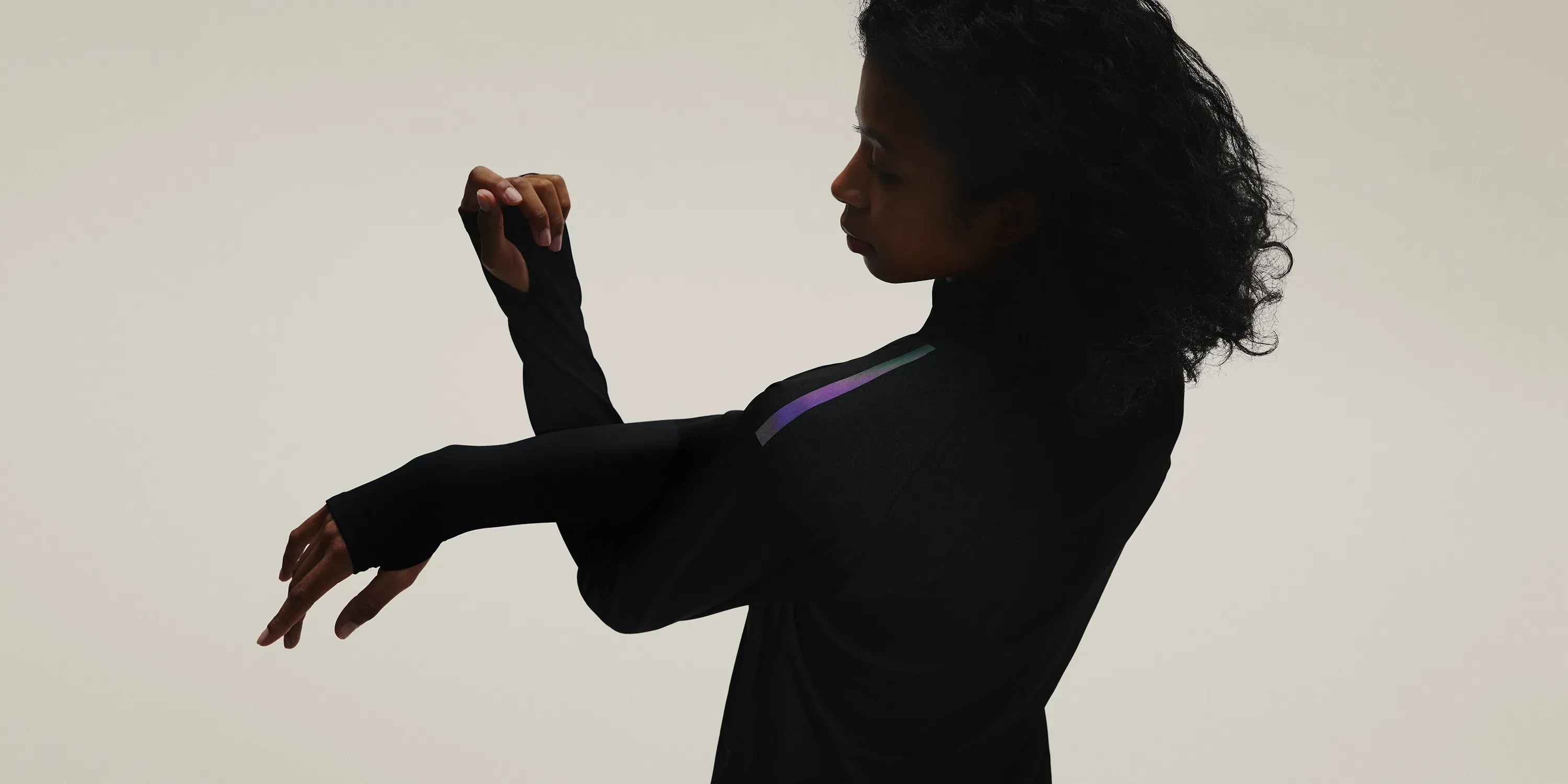 Upper-body silhouette of a woman stretching, with a glowing shoulder reflector, expressing the concept of SOLAR-PERFORMANCE WEAR.